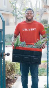 Portrait de Lucas BERTRAND portant une cagette de légumes