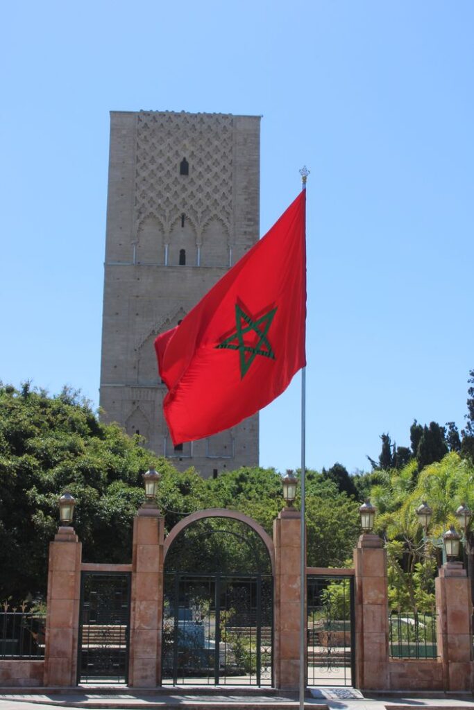 View of Hassan Tower with Moroccan flag in Rabat, showcasing Moroccan architecture.